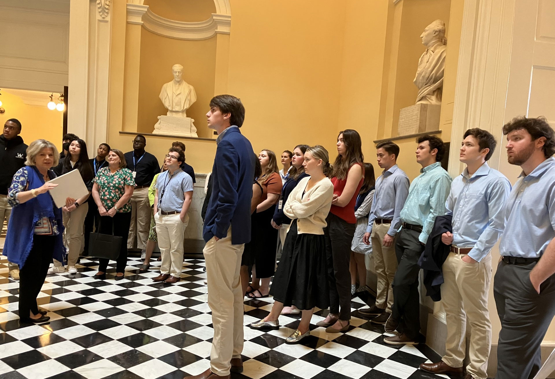 Un grupo de personas de pie frente a una estatua